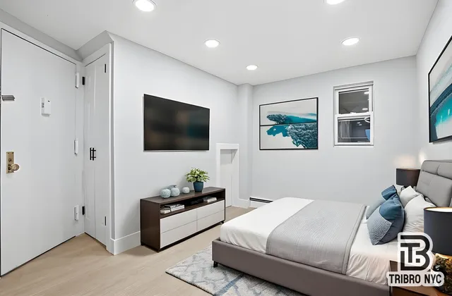 a bedroom with a bed and a flat screen tv