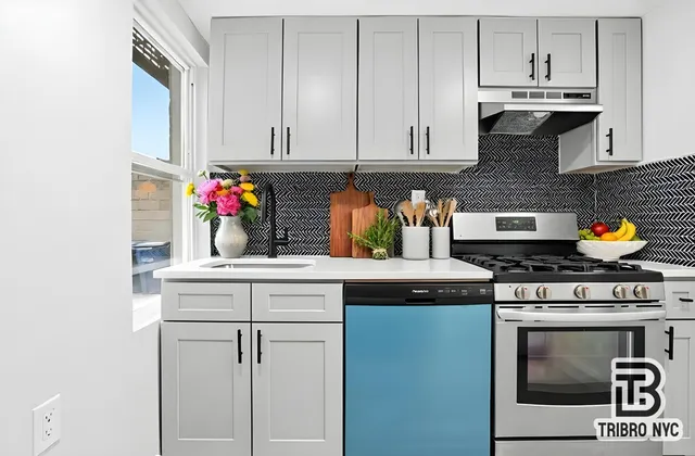 a kitchen with granite countertop white cabinets and stainless steel appliances