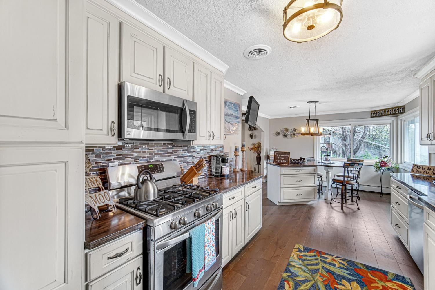42 Ogden Road Portage, IN 46368 - Photo 18 of 40 a kitchen with stainless steel appliances granite countertop a stove top oven a sink dishwasher a dining table and chairs with wooden floor