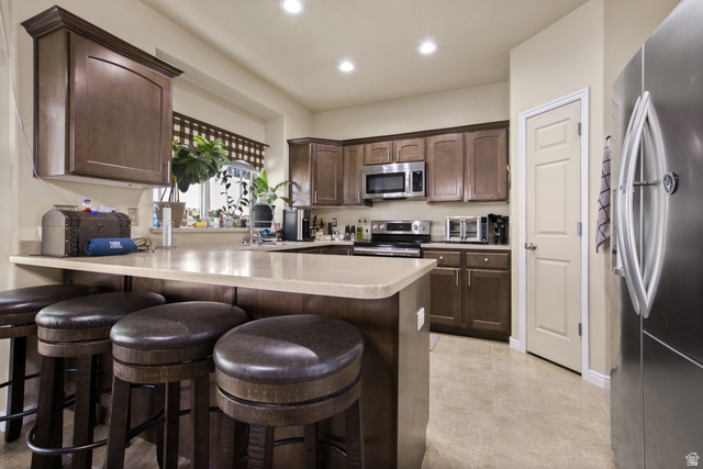 2005 Redtail Way Layton, UT 84040 - Photo 13 of 37 Kitchen featuring wood-finish cabinetry, stainless steel appliances, light-toned countertops, and recessed lighting