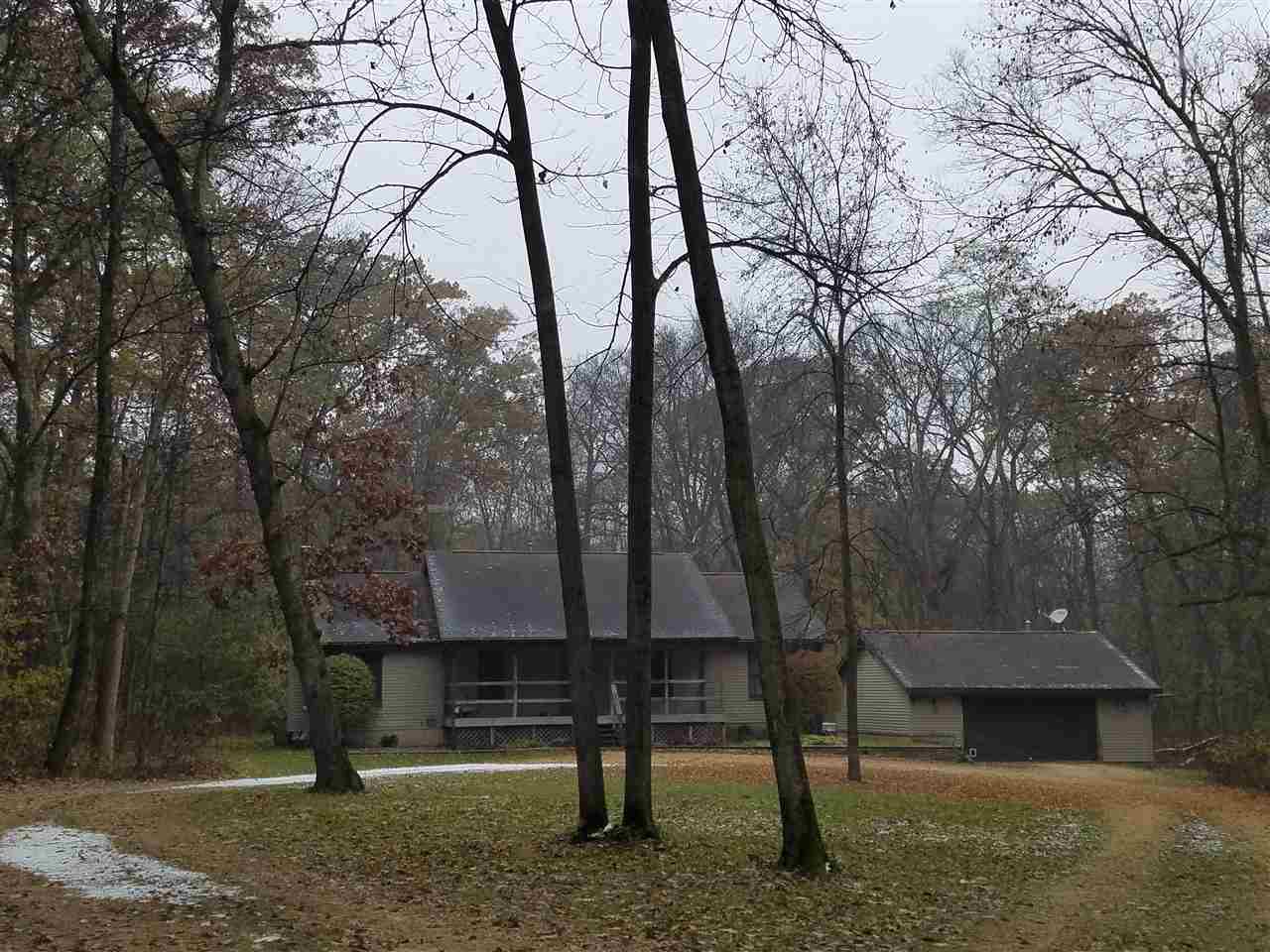 a view of a backyard with large trees and wooden fence