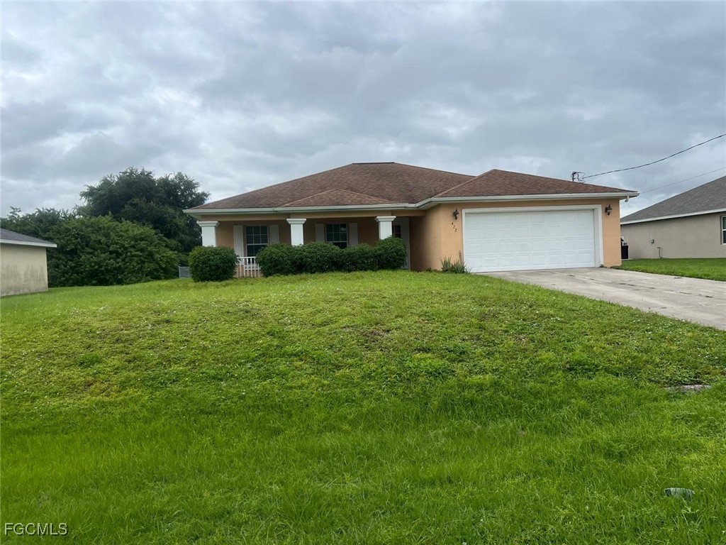 2923 3rd Street Southwest Lehigh Acres, FL 33976 - Photo 2 of 19 a front view of a house with yard and green space