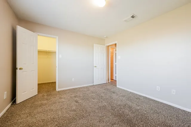 an empty room with windows and ceiling fan