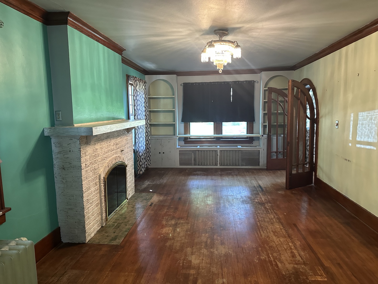 1418 North Sheridan Road Peoria, IL 61606 - Photo 14 of 34 a view of a livingroom with a fireplace chandelier and windows