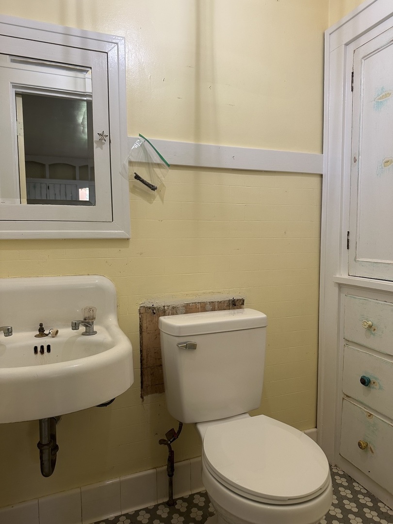1418 North Sheridan Road Peoria, IL 61606 - Photo 16 of 34 a bathroom with a sink a toilet and a mirror