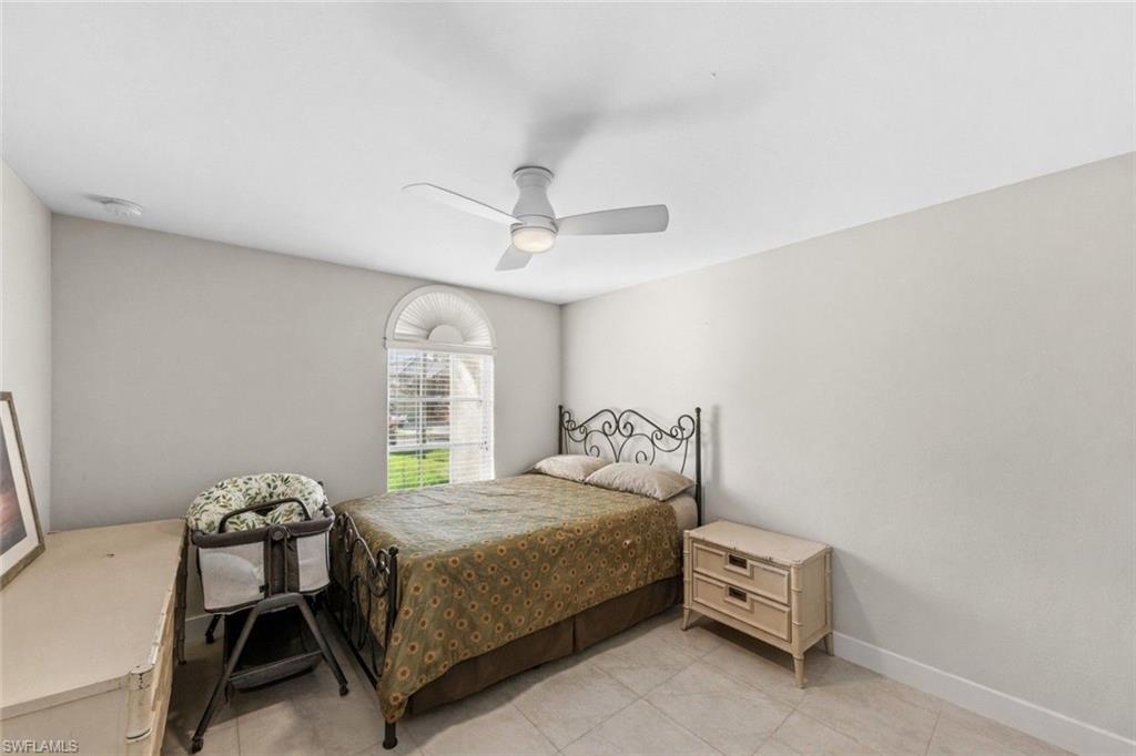 4724 Riverside Drive Estero, FL 33928 - Photo 24 of 44 a bedroom with a bed and a chandelier