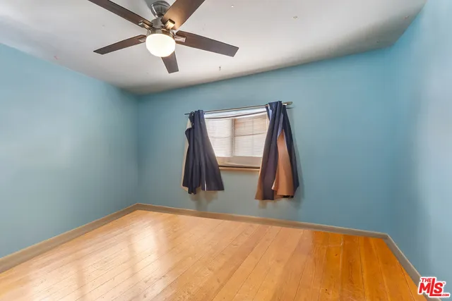 a view of a room with a wooden floor and a ceiling fan