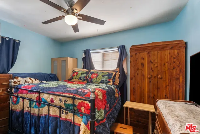 a bedroom with two beds and a desk