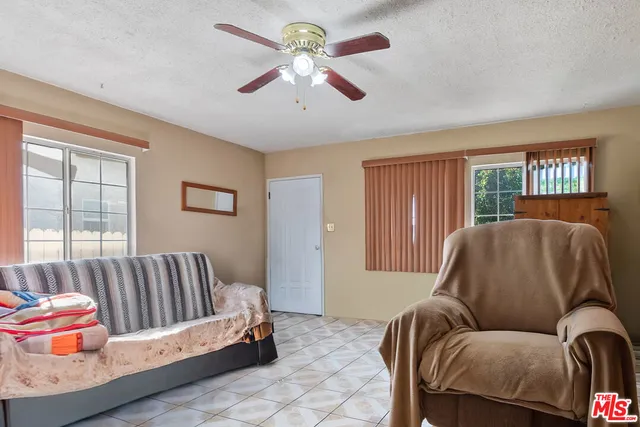 a living room with furniture ceiling fan and a window