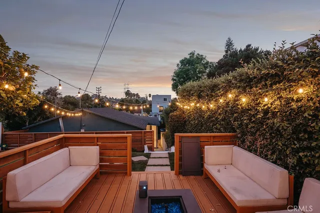 a front view of a house with a yard and mountain view in back