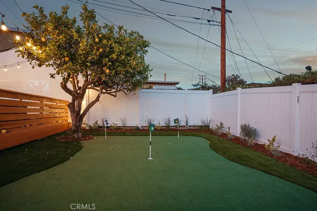 an aerial view of a house with a yard and a large tree