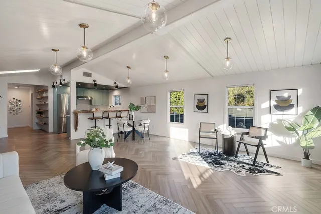 a living room with furniture kitchen view and a chandelier