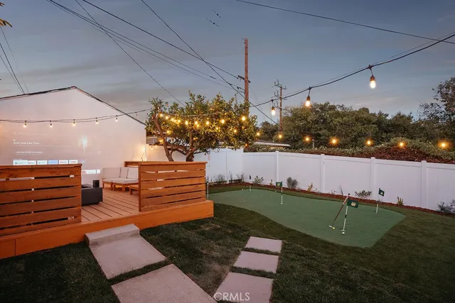 a view of a small house with a small yard and a large tree
