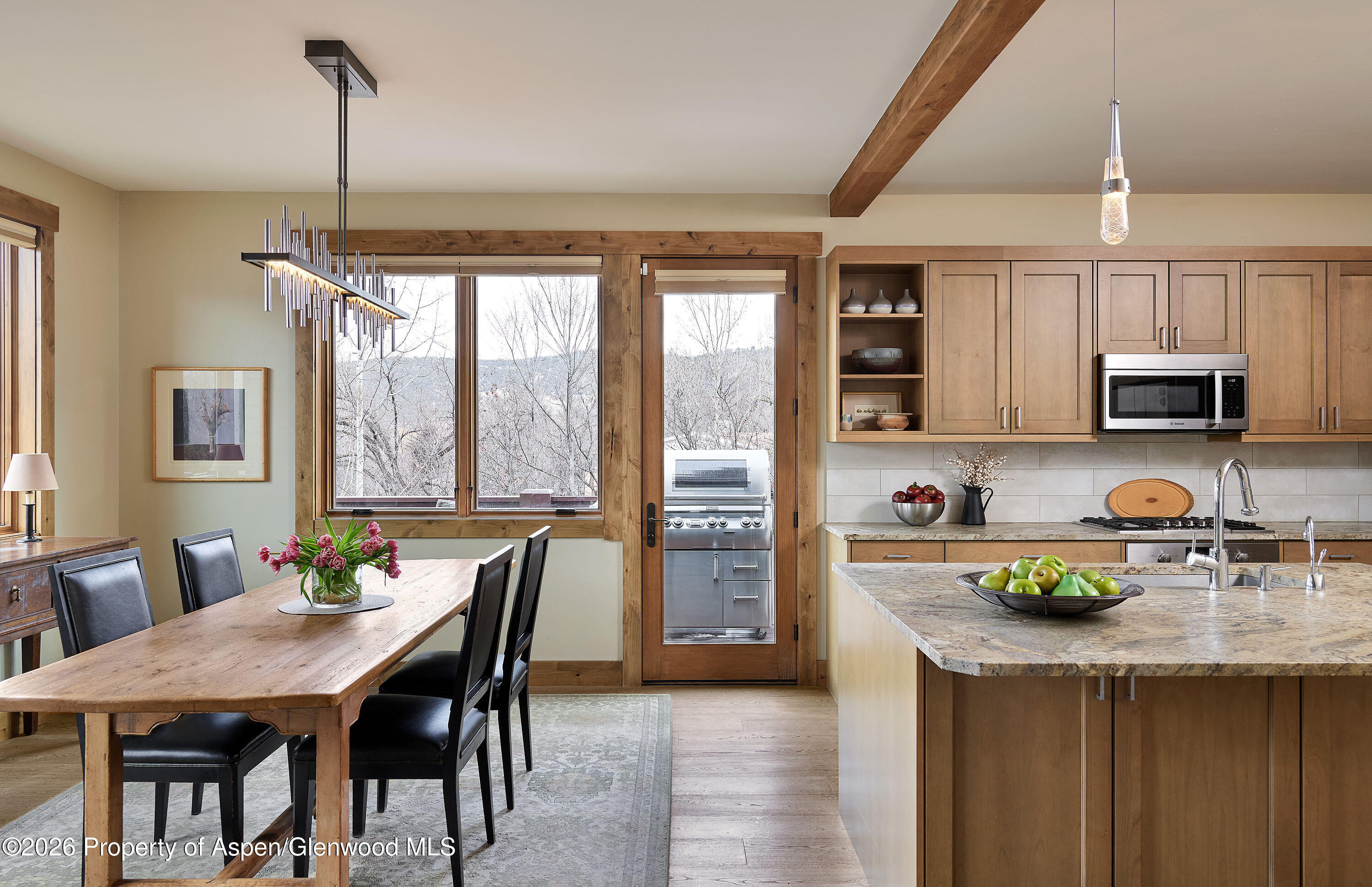 219 Overlook Ridge Basalt, CO 81621 - Photo 6 of 34 a kitchen with stainless steel appliances granite countertop a stove top oven a sink a dining table and chairs with wooden floor