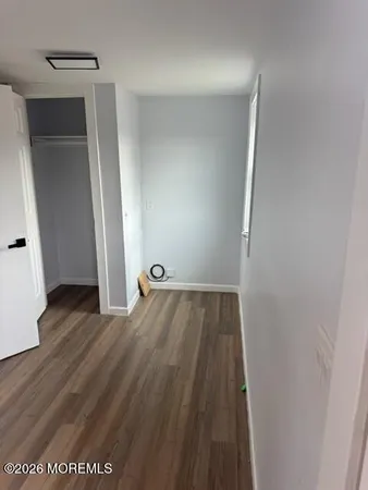 an empty room with wooden floor and entrance