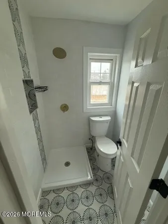 a bathroom with a toilet and a shower