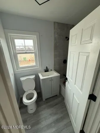 a bathroom with a sink toilet and window
