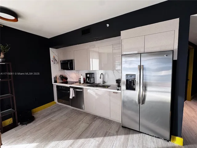 a kitchen with stainless steel appliances a refrigerator sink and microwave