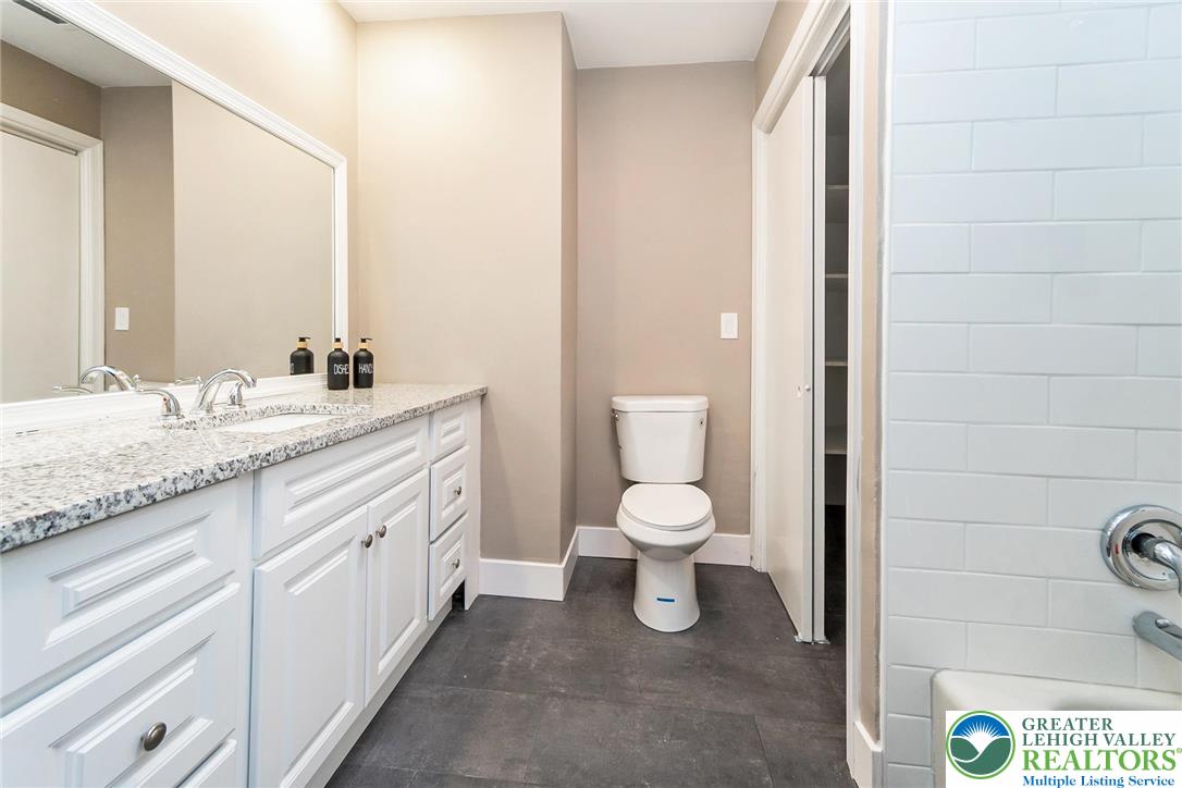 7243 Kingstead Drive Slatington, PA 18080 - Photo 14 of 36 a bathroom with a granite countertop sink a toilet and a mirror