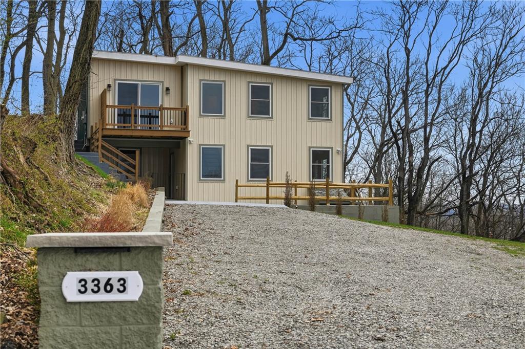 a view of house with sign board and a yard