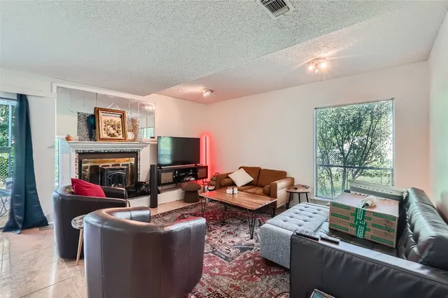 a living room with furniture a fireplace and a window