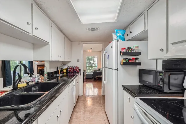 a kitchen with a refrigerator and a sink