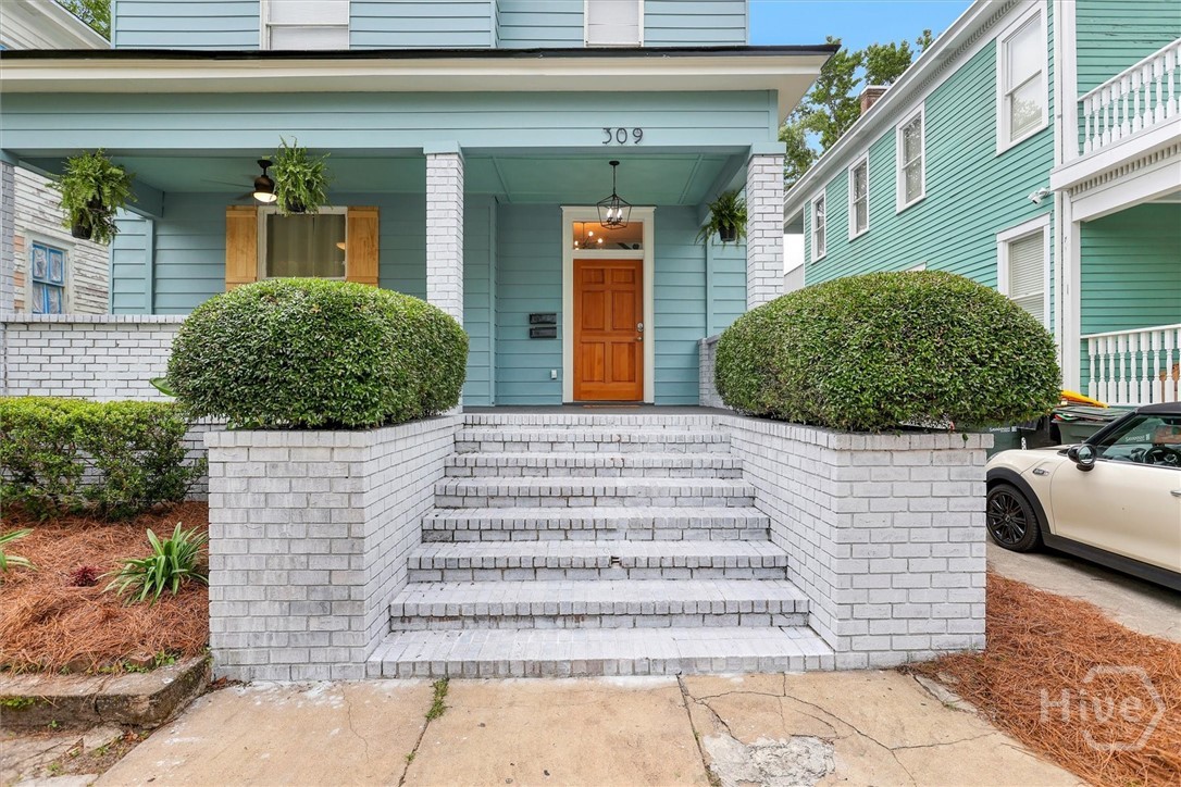 309 West 33rd Street Savannah, GA 31401 - Photo 4 of 35 Charming front porch entry with classic brick steps, manicured hedges, and inviting curb appeal.