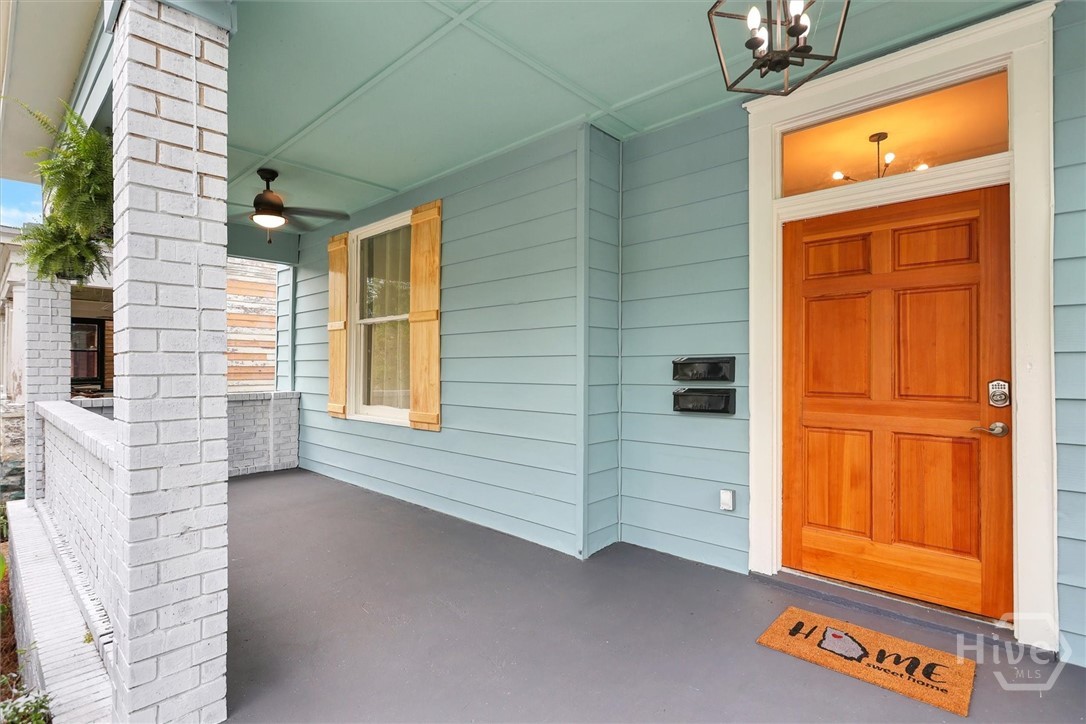309 West 33rd Street Savannah, GA 31401 - Photo 5 of 35 Inviting covered front porch with classic brick accents and a warm wood entry door.