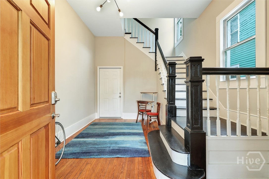 309 West 33rd Street Savannah, GA 31401 - Photo 6 of 35 Bright entry foyer featuring hardwood floors, high ceilings, and a staircase with classic railing details.