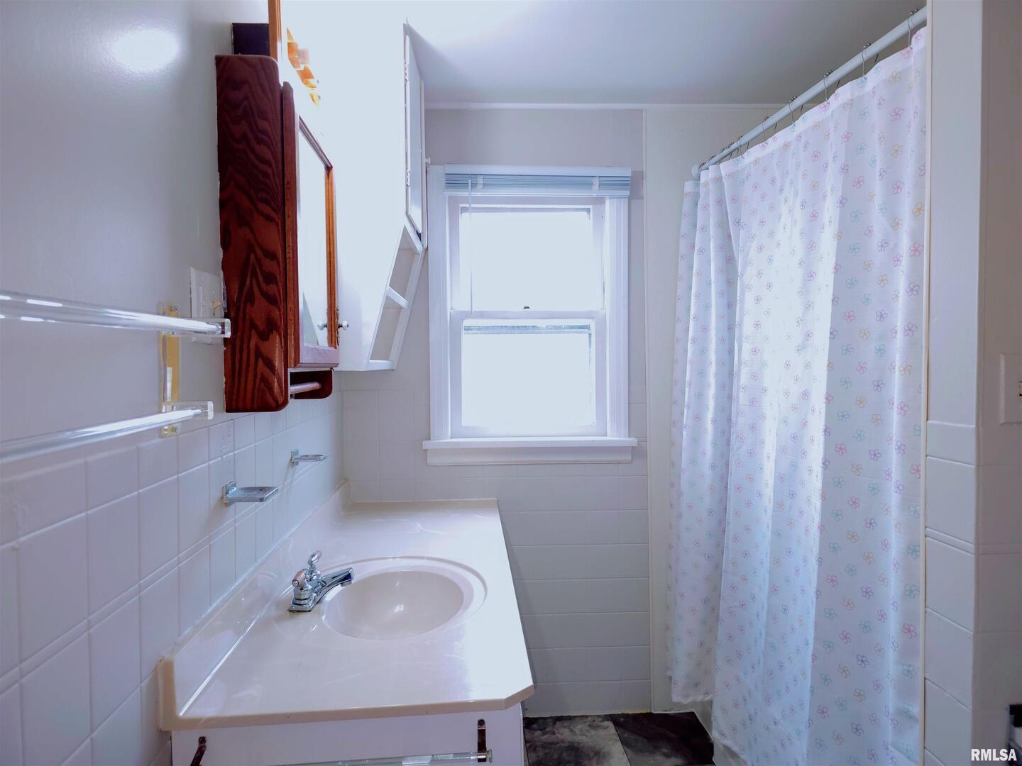 603 Adams Street Muscatine, IA 52761 - Photo 12 of 17 a bathroom with a sink and a mirror