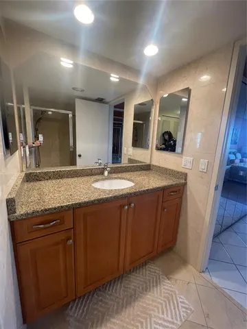 a bathroom with a granite countertop sink and a mirror