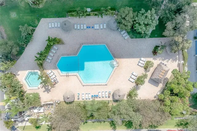 an aerial view of a house with a yard and tennis court