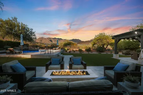 a view of a swimming pool and lounge chairs in back of the house