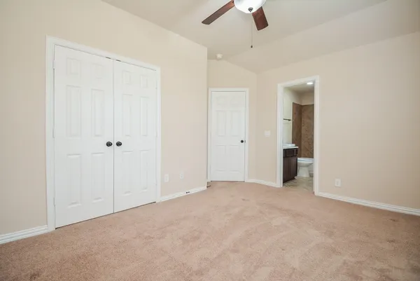 an empty room with ceiling fan and window