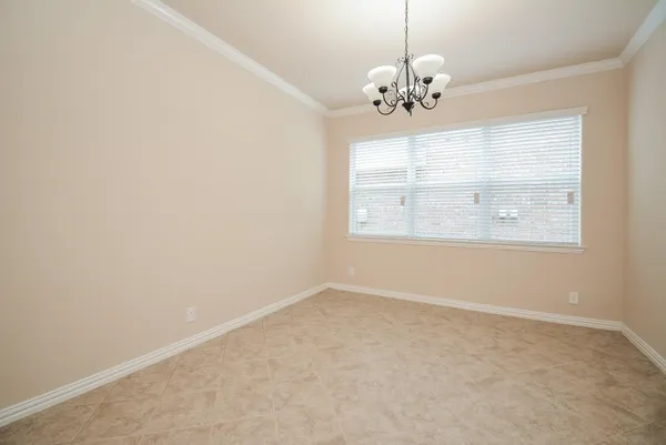 an empty room with chandelier and windows