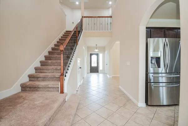 a view of entryway and hall with a refrigerator