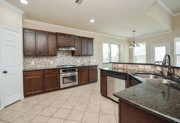 a kitchen with a stove sink and cabinets