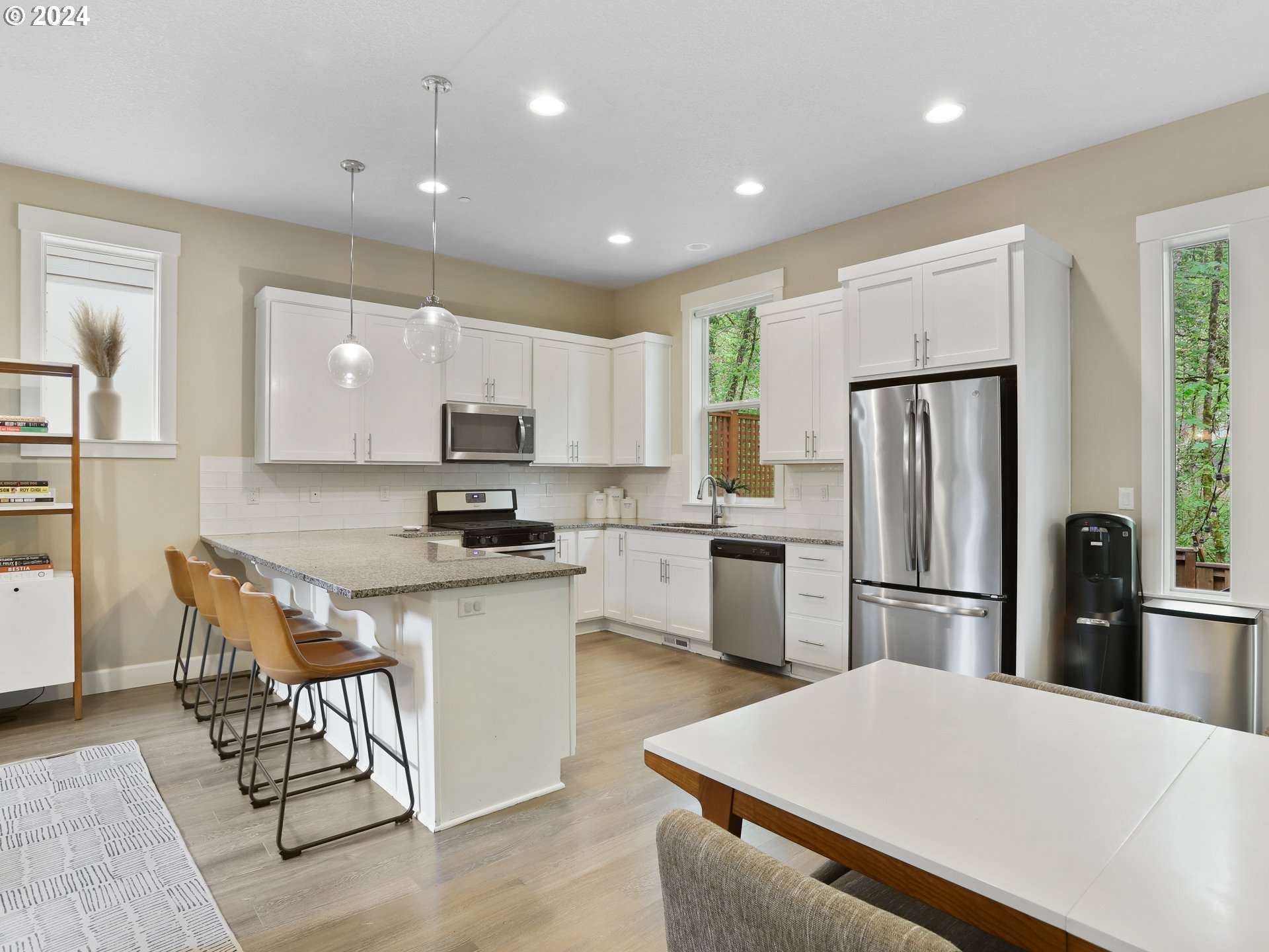 8087 Southwest Oldham Drive Beaverton, OR 97007 - Photo 14 of 46 a kitchen with stainless steel appliances granite countertop a refrigerator a stove top oven a sink a dining table and chairs