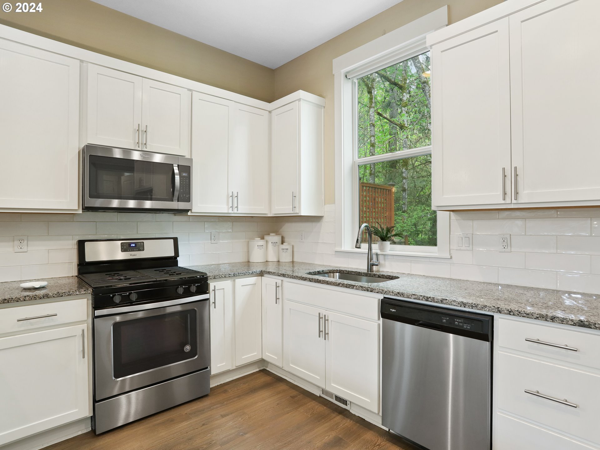 8087 Southwest Oldham Drive Beaverton, OR 97007 - Photo 16 of 46 a kitchen with granite countertop white cabinets appliances a window and a sink