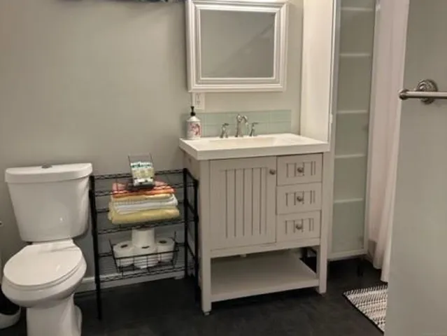 a bathroom with a sink toilet and a mirror