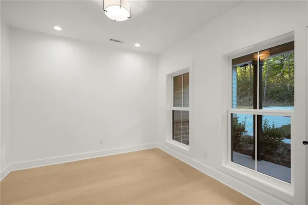 a view of an empty room with a window and kitchen view