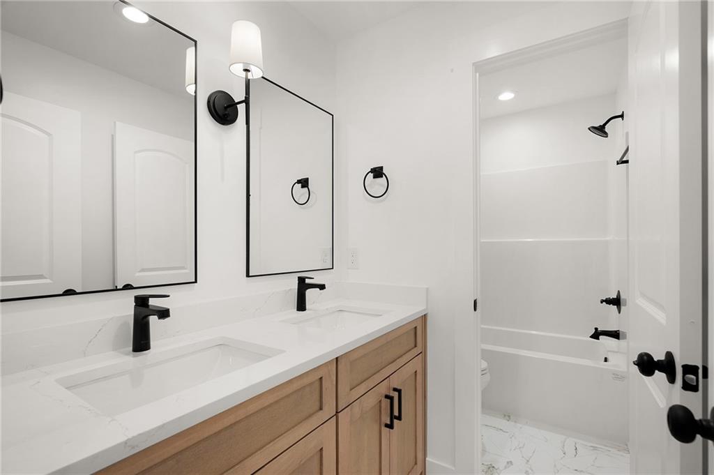 140 Cambridge Court Calhoun, GA 30701 - Photo 26 of 29 a bathroom with a shower sink and a mirror