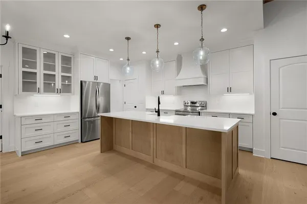 a kitchen with stainless steel appliances granite countertop a sink a stove and a refrigerator