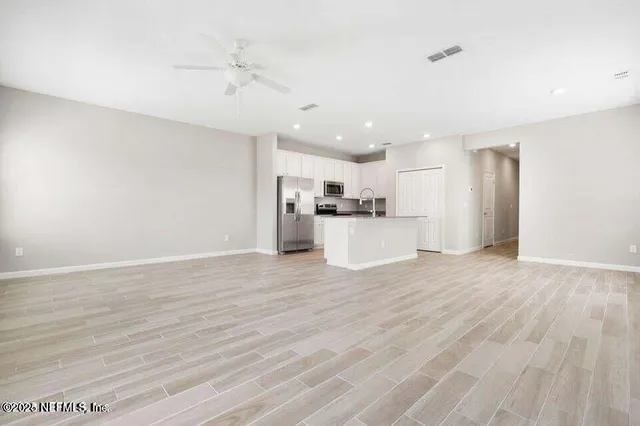 a view of a kitchen with a sink and a refrigerator