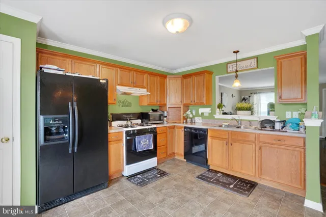 a kitchen with stainless steel appliances granite countertop a refrigerator and a stove top oven
