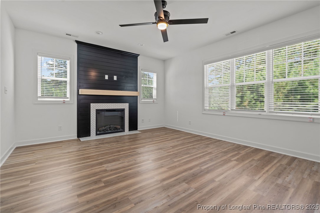 58 Magnolia Grv Way Cameron, NC 28326 - Photo 12 of 25 a view of empty room with wooden floor fireplace and a window