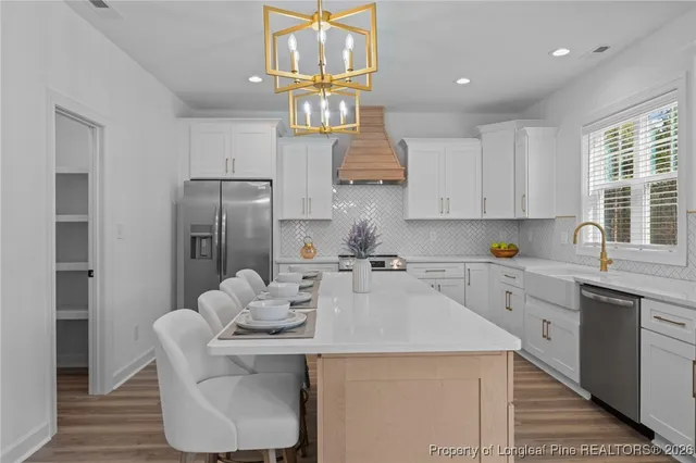 a kitchen with a sink stove and wooden floor