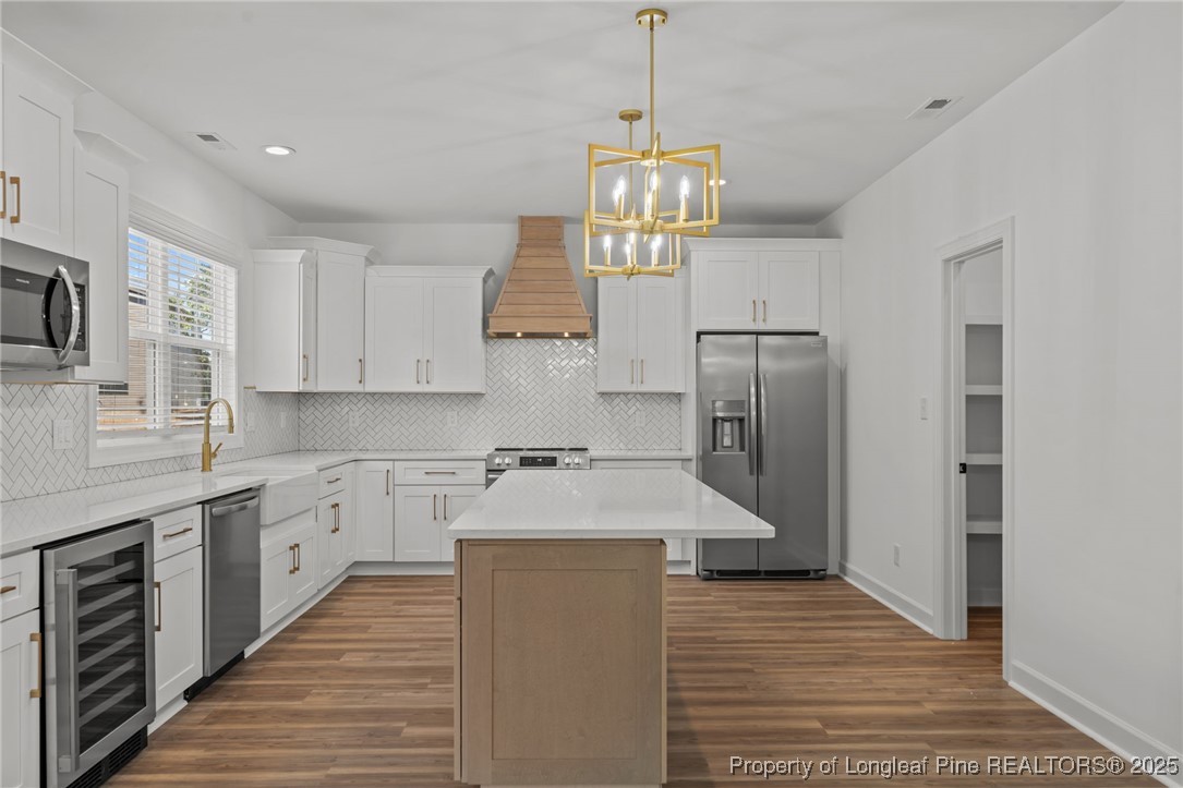 58 Magnolia Grv Way Cameron, NC 28326 - Photo 7 of 25 a kitchen with stainless steel appliances granite countertop a refrigerator a sink dishwasher a stove and white cabinets with wooden floor