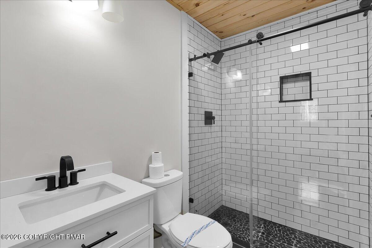 309 Selig Road Pocono Lake, PA 18347 - Photo 16 of 25 a bathroom with a toilet sink vanity and mirror