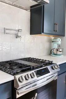 a living room with furniture kitchen view and a large window